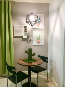 a dining room table with a cactus and two chairs at VL Garden Suites in Tagbilaran City