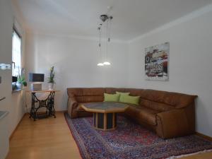 Apartment in Trittenheim with Terrace and Garden في تريتينييم: غرفة معيشة مع أريكة بنية وطاولة