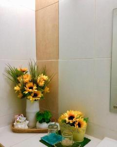 a bathroom with two vases with flowers on a counter at VL Garden Suites in Tagbilaran City