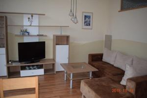 a living room with a couch and a flat screen tv at Ferienwohnung Weinlaube in Bergrheinfeld