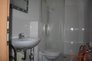 a white bathroom with a sink and a toilet at Ferienwohnung Weinlaube in Bergrheinfeld