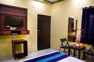 una camera da letto con un letto e una TV a parete di Udee's Homestay ad Agra