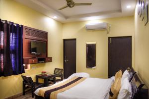 una camera da letto con un letto e una TV in una stanza di Udee's Homestay ad Agra Altre 32 foto
