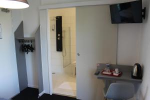 a bathroom with a shower with a sink and a chair at Villa Hotel in Troyes +53 photos