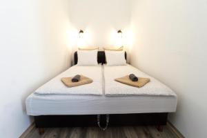 a bedroom with a bed with two slippers on it at Karikum Large in Budapest