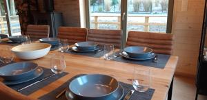 une table en bois avec des bols, des assiettes et des verres dans l'établissement Chalet Tjaffers lodge, à Durbuy