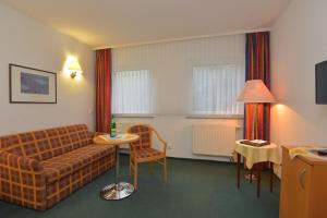 un soggiorno con divano e tavolo di Hotel Am Wald -GARNI- a Elgersburg