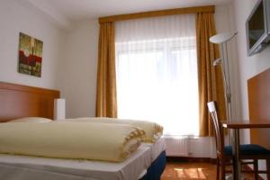 1 dormitorio con cama y ventana grande en Evido Rooms, en Salzburgo