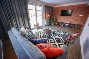 克雷尼察的住宿－Domek nad stawem，客厅设有蓝色的沙发和砖墙