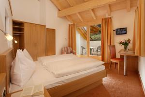 a bedroom with a bed in a room with a window at Hotel Neuhausmühle in Vilpiano