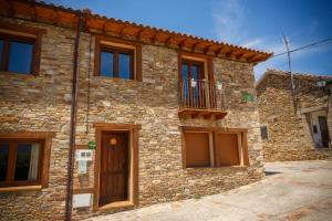 a stone house with a balcony on the side of it at El Bulin de Paredes in Paredes de Buitrago