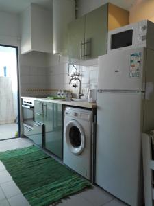 a kitchen with a refrigerator and a washing machine at Ruffus Beach House in Portimão