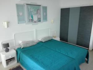 a bedroom with a bed with a turquoise blanket at Ruffus Beach House in Portimão