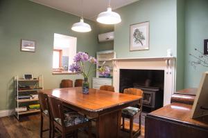 a dining room with a table and a fireplace at Wayfarers Cottage in Goolwa
