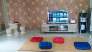 uma sala de estar com dois repousa-pés vermelhos e azuis e uma televisão em Asaby Homestay Yogya em Yogyakarta