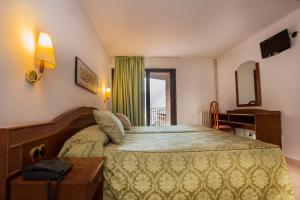 Habitación de hotel con cama grande y ventana en Hotel Cervol en Andorra la Vella