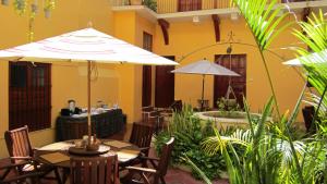 um pátio exterior com mesas e guarda-sóis em Castelmar Hotel em Campeche
