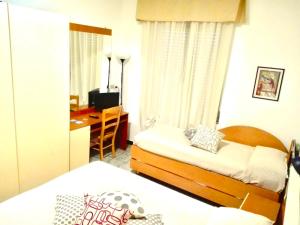 a hotel room with two beds and a desk and a bedroom at Albergo Albatros in Pietra Ligure