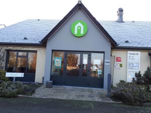 a building with a door with a green sign on it at Campanile Sablé-Sur-Sarthe Vion in Sablé-sur-Sarthe