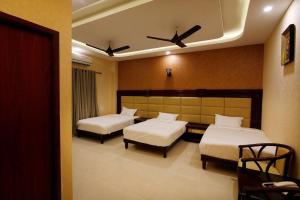 Un dormitorio con dos camas y un ventilador de techo. en RB GRAND RESIDENCY, en Kanchipuram