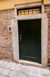 a door that is open on a brick wall at Golden Suite in Venice