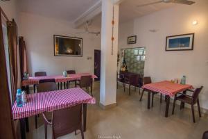 a dining room with pink tables and chairs at Iora Guest House in Bharatpur