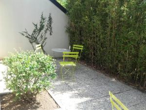 a green bench sitting in front of a brick wall at Campanile Sablé-Sur-Sarthe Vion in Sablé-sur-Sarthe