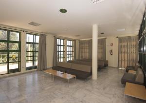 a living room with couches and tables and windows at Albergue Inturjoven Algeciras-Tarifa in Algeciras