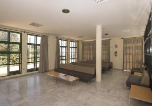 salon z kanapami, stołami i oknami w obiekcie Albergue Inturjoven Algeciras-Tarifa w mieście Algeciras