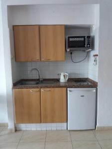 a small kitchen with a sink and a microwave at Los Geranios in Adeje