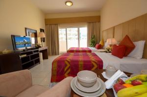 a hotel room with two beds and a television at Parkside Hotel Apartment in Dubai