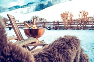 a bowl of wine bottles sitting on a chair in the snow at Haus Ennsegg by Schladming-Appartements in Haus im Ennstal