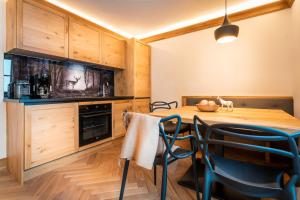una cucina con tavolo e sedie in legno di Haus Ennsegg by Schladming-Appartements a Haus im Ennstal