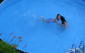 
a woman is in the pool with a blue ball at Hotel Panzió 100 in Szentendre
