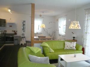 a living room with a green couch and a table at Haus Lavendel in Lancken