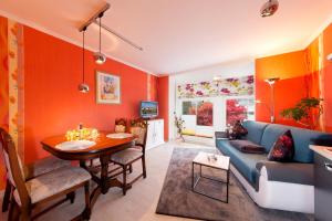 a living room with orange walls and a blue couch at Haus Mozart in Binz