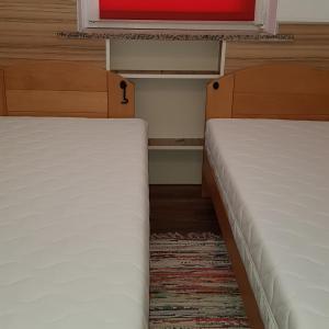 2 Betten in einem kleinen Zimmer mit Fenster in der Unterkunft Zagreb center near main square in Zagreb