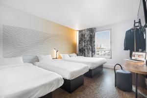 um quarto de hotel com duas camas e uma janela em B&B HOTEL Lyon Centre Part-dieu Gambetta em Lyon