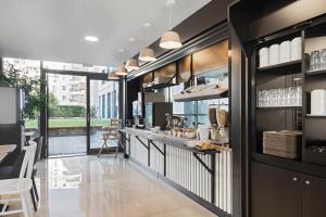 a kitchen with a counter and a table and chairs at B&B HOTEL Lyon Centre Part-dieu Gambetta in Lyon