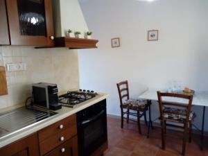 a kitchen with a stove and a counter with chairs at Affittacamere Graziella in Vernazza