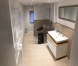 ein Bad mit einem Waschbecken und einer Dusche in der Unterkunft Arkona 3 in Putgarten