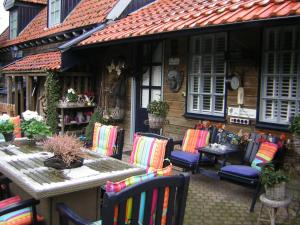 eine Terrasse mit Stühlen, einem Tisch und einem Haus in der Unterkunft Prive tuinhuis B&B Elly in Sint Pancras
