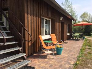 eine Terrasse mit Stühlen, einem Tisch und einem Sonnenschirm in der Unterkunft Ferienwohnung Rosi Stoppa in Burg