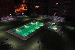a swimming pool at night with green lights at Los Sauces II in Jaca
