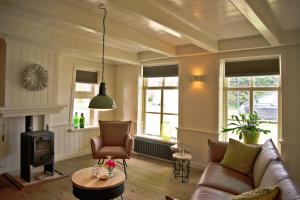 a living room with a couch and a fireplace at 't Stee fan Anne P. in Rottevalle