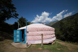熱德爾的住宿－Yourtes Mongoles Gavarnie，圆顶帐篷,衬托着粉红色的盖子,位于田野中