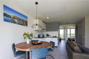 a kitchen and a dining room with a table and chairs at Onderlandhuis 38 in Chaam