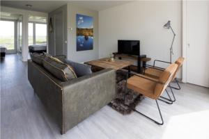 ein Wohnzimmer mit einem Sofa und einem Tisch in der Unterkunft Onderlandhuis 38 in Chaam