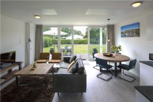 uma sala de estar com um sofá e uma mesa em Onderlandhuis 38 em Chaam