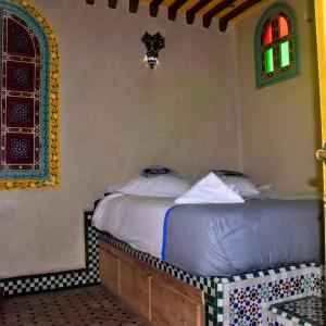 een slaapkamer met een bed in een kamer bij Riad Razoli Sidi Fateh in Rabat